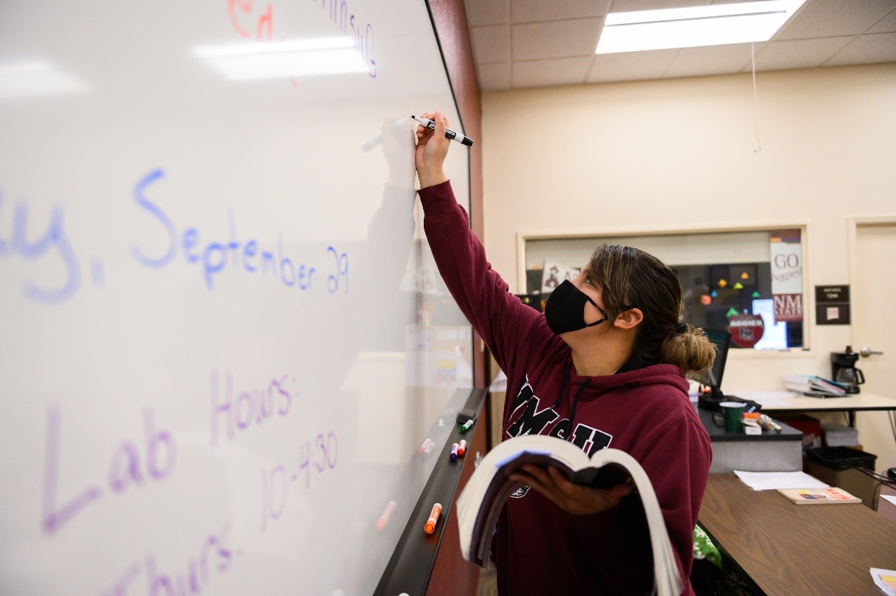 Mathematics' Student writing equation on the whiteboard
